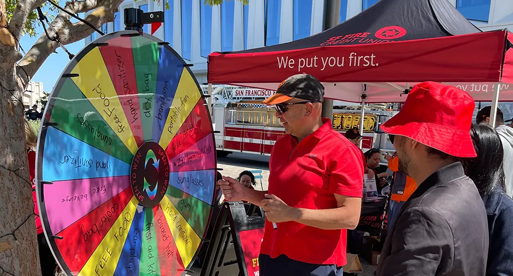 Man spinning giveaway wheel at SFFire community event