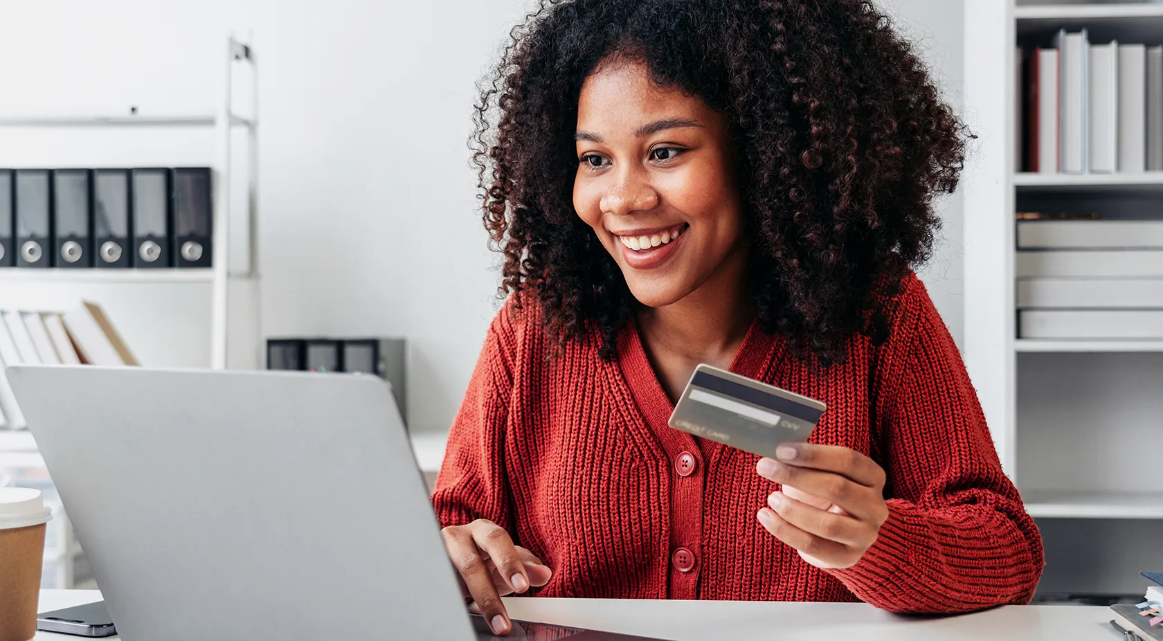 African American woman on laptop with Visa card in hand