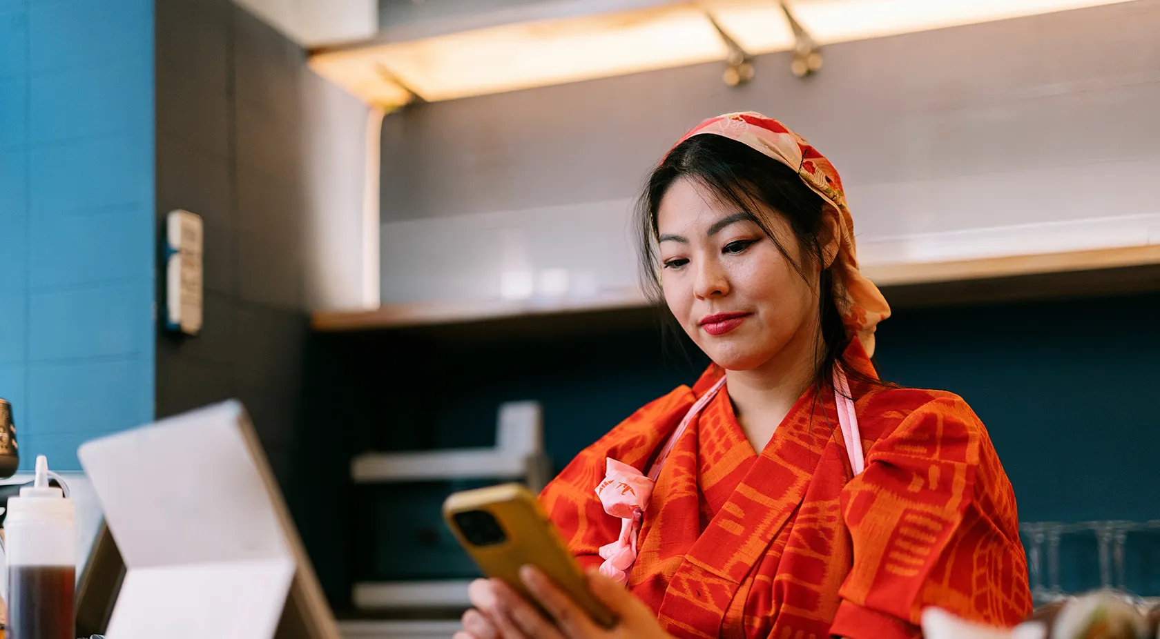 lady looking at her phone while working in restaurant
