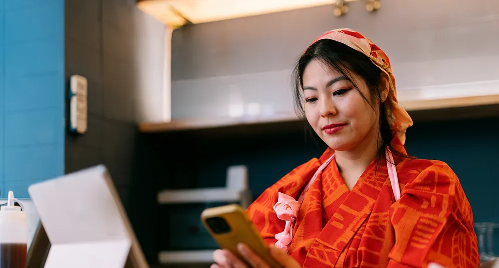 lady looking at her phone while working in restaurant