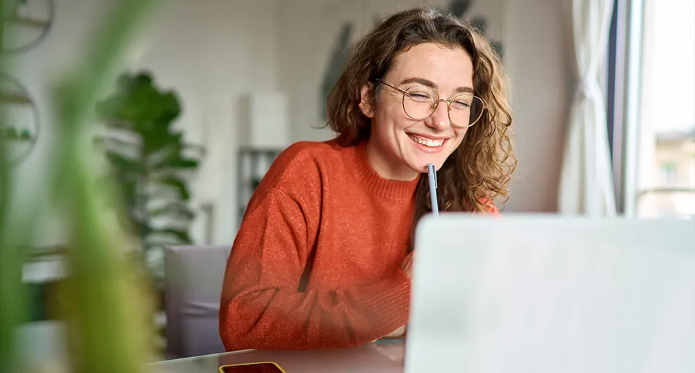 Lady smiling while looking at her laptop