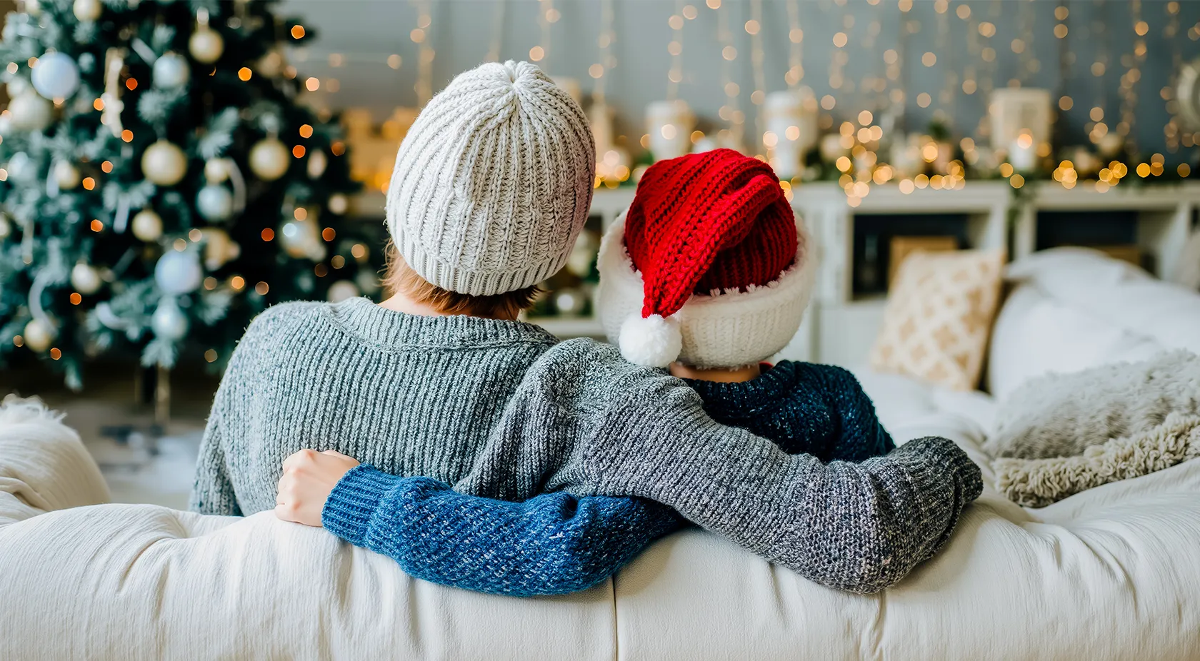 A couple siting on their couch looking at the Christmas tree