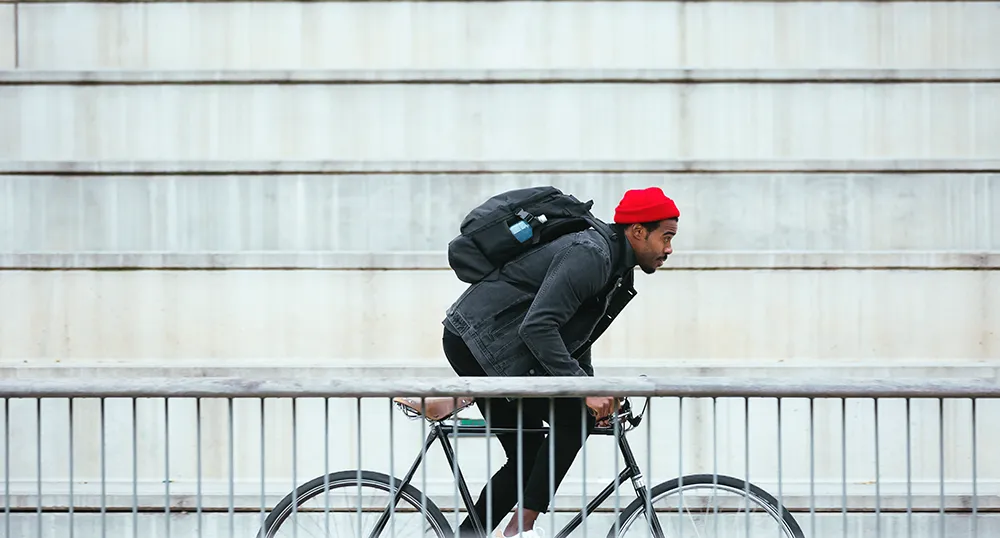 Guy cycling his bike past steps