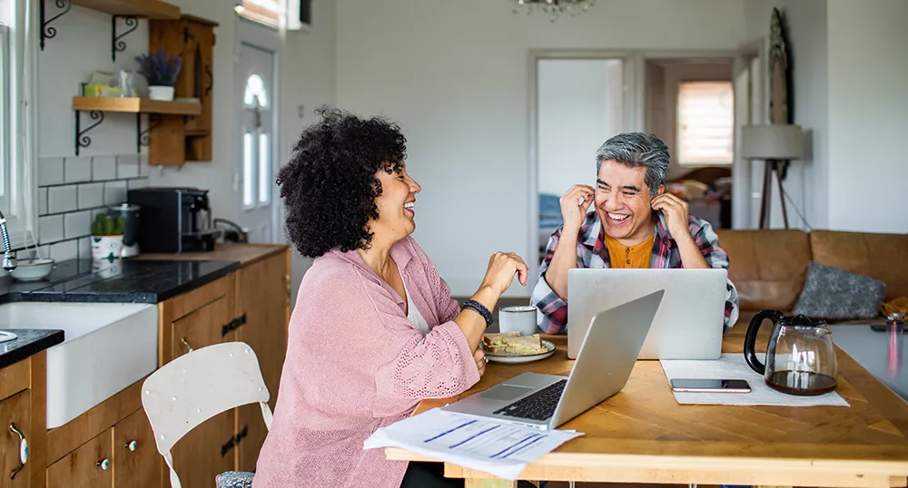 Two people on their laptops speaking to each other