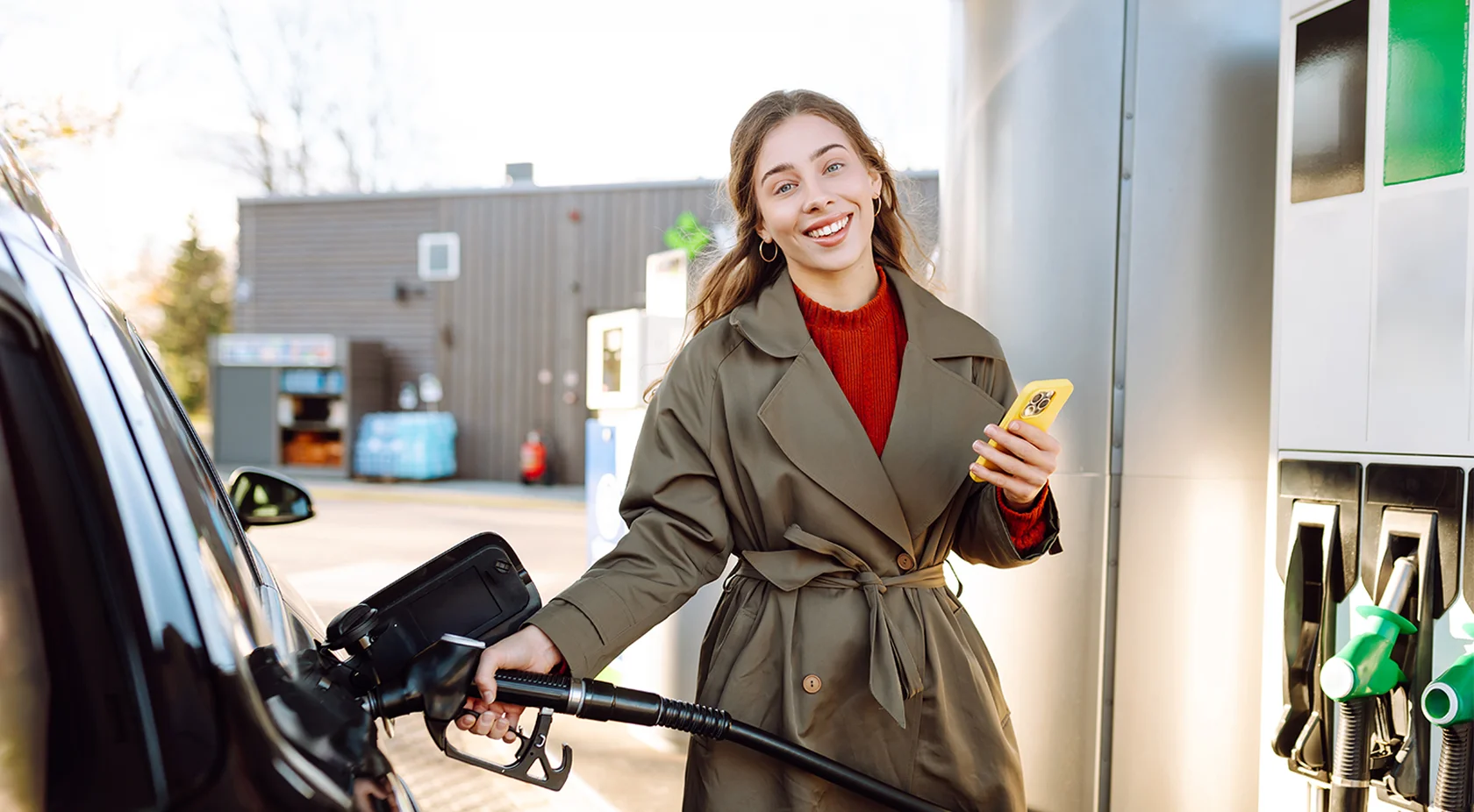 Women filling gas on her phone