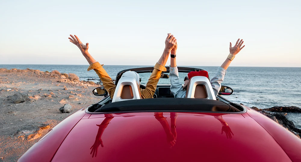In red car with hands up