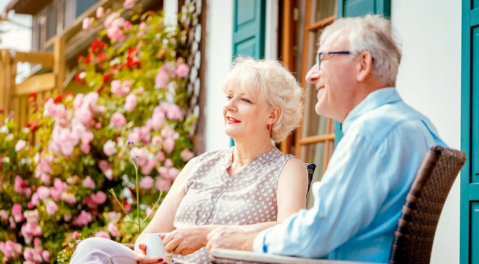 elderly couple sitting outside their home