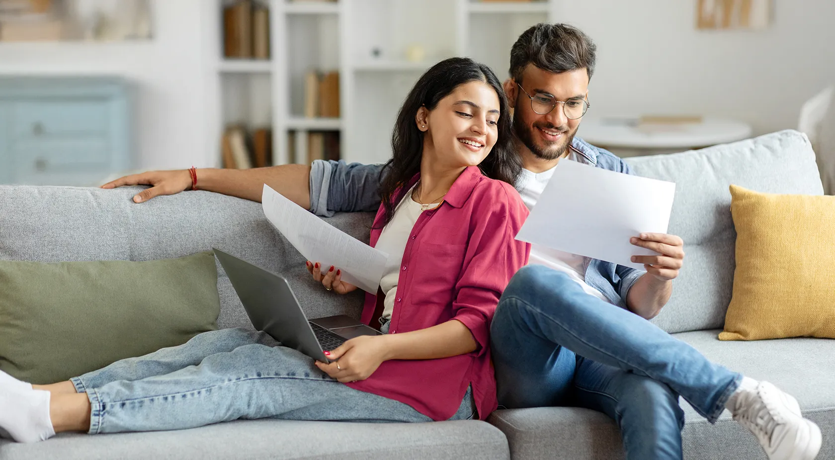 Couple Sitting on sofa reading paper