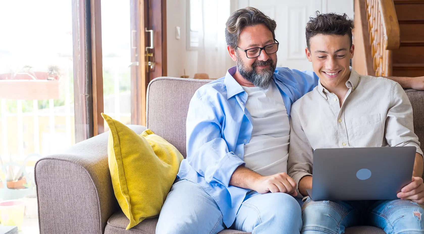 Father helping son on laptop