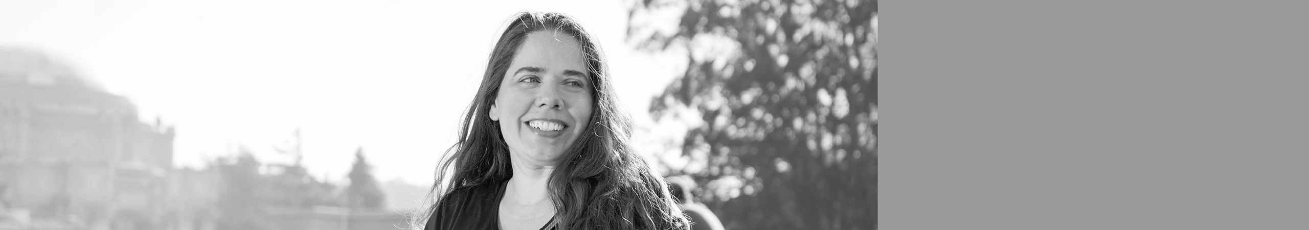 Smiling woman looks hopeful. Palace of Fine arts is in the background.