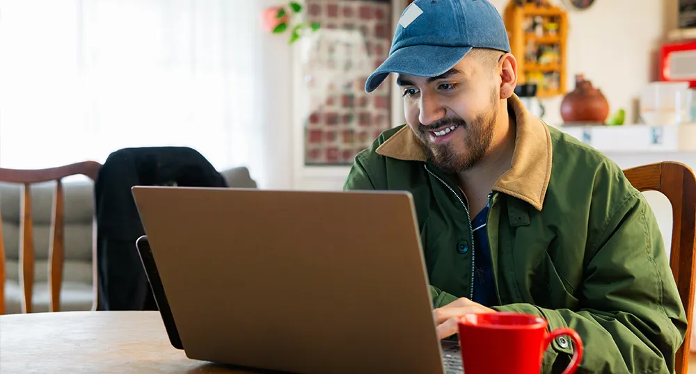 Guy sitting and looking at his laptop