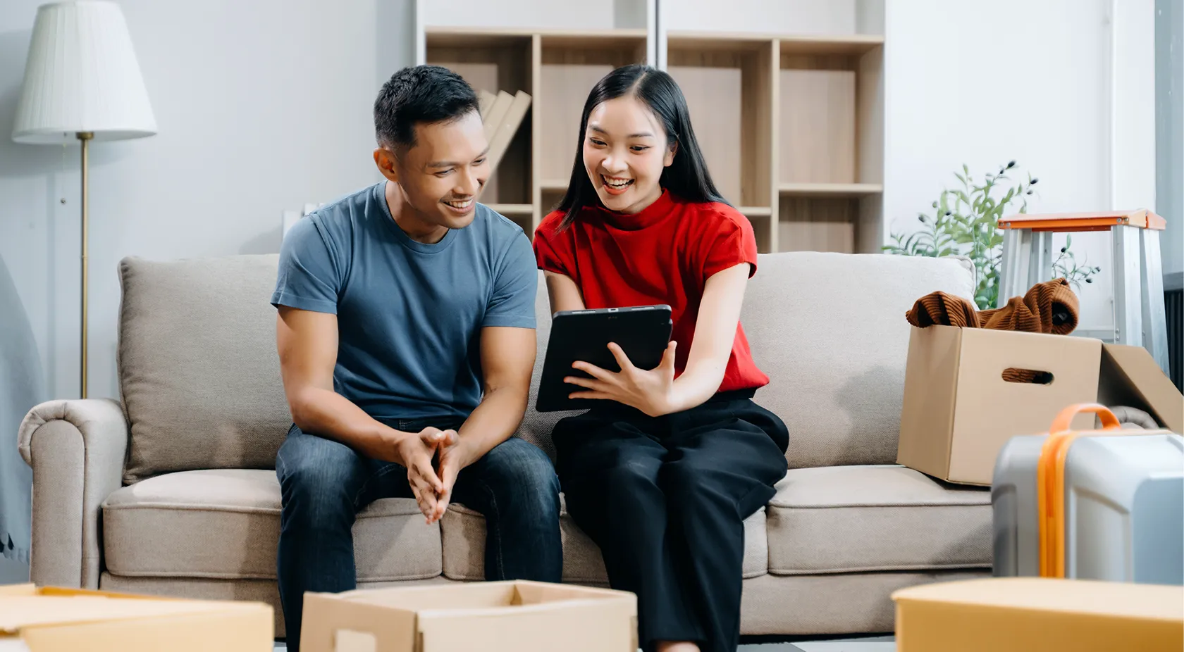 couple on couch looking at tablet
