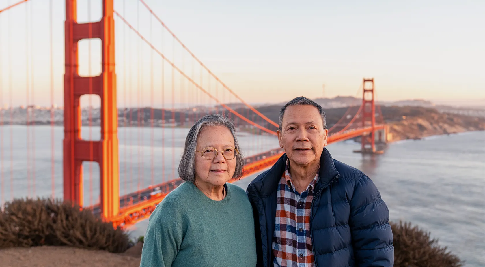 Couple standing on Marin headlands with Golden Gate Bridge in the background
