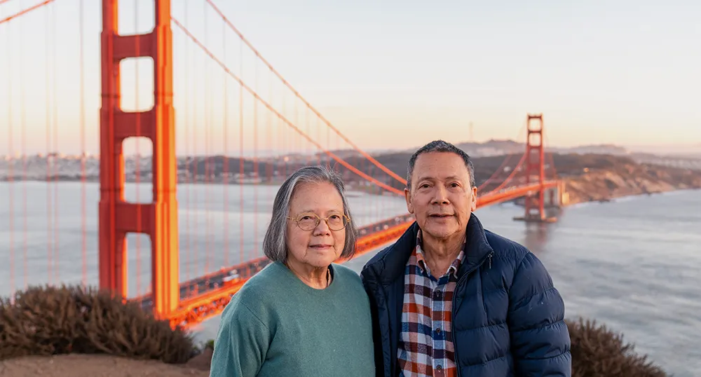 Couple standing on Marin headlands with Golden Gate Bridge in the background