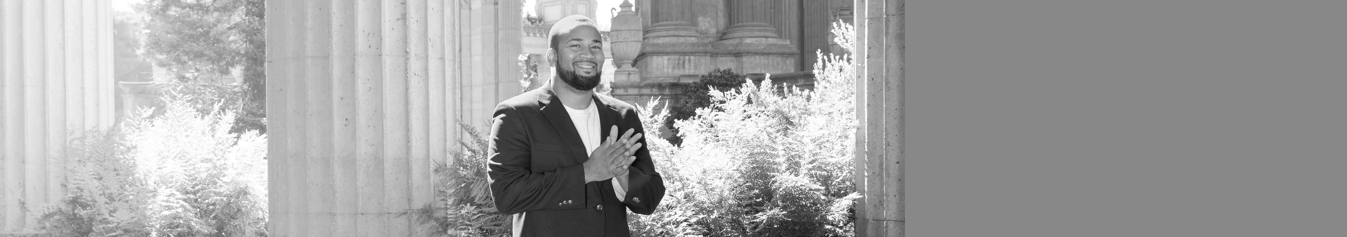 Waist-up shot of man in blazer, smiling and rubbing his hands together.