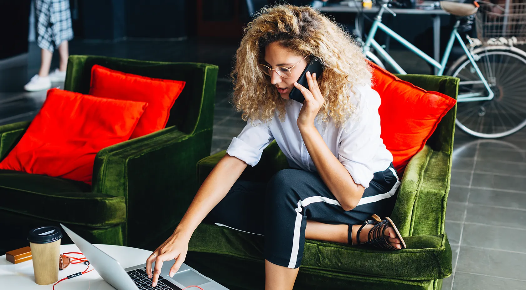 Lady on phone and looking at her laptop